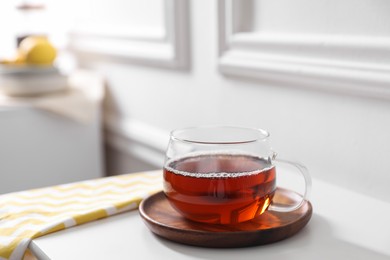 Tasty hot tea in cup on white table, closeup