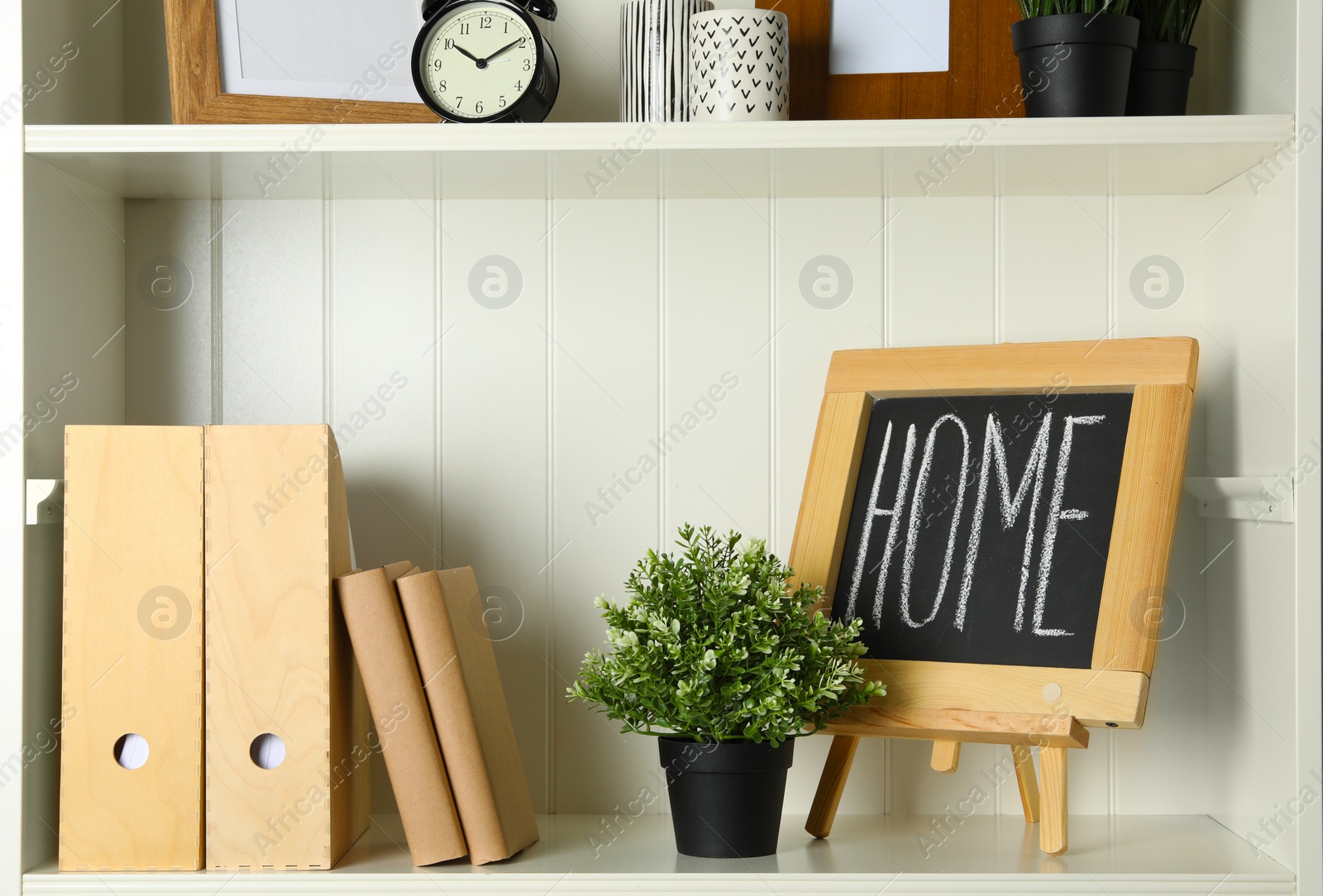 Photo of White shelving unit with chalkboard and decorative elements