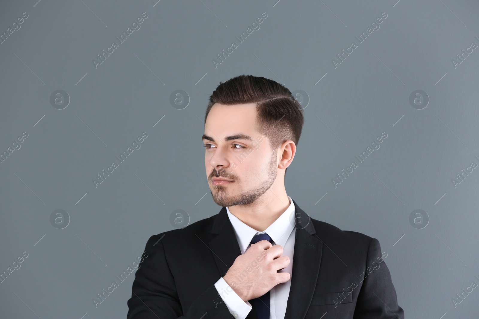 Photo of Portrait of young man with beautiful hair on grey background