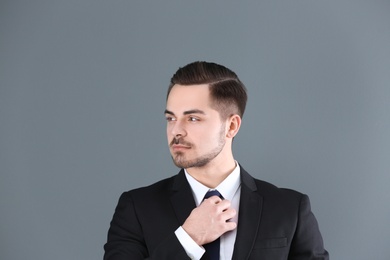 Portrait of young man with beautiful hair on grey background