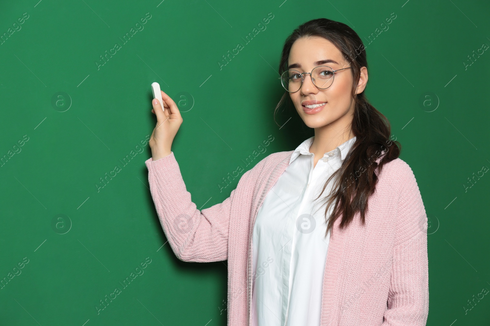 Photo of Portrait of beautiful young teacher near chalkboard