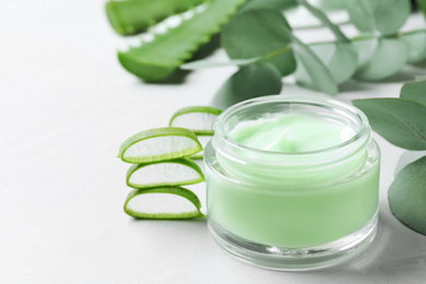 Photo of Jar of organic cream and aloe vera on light table