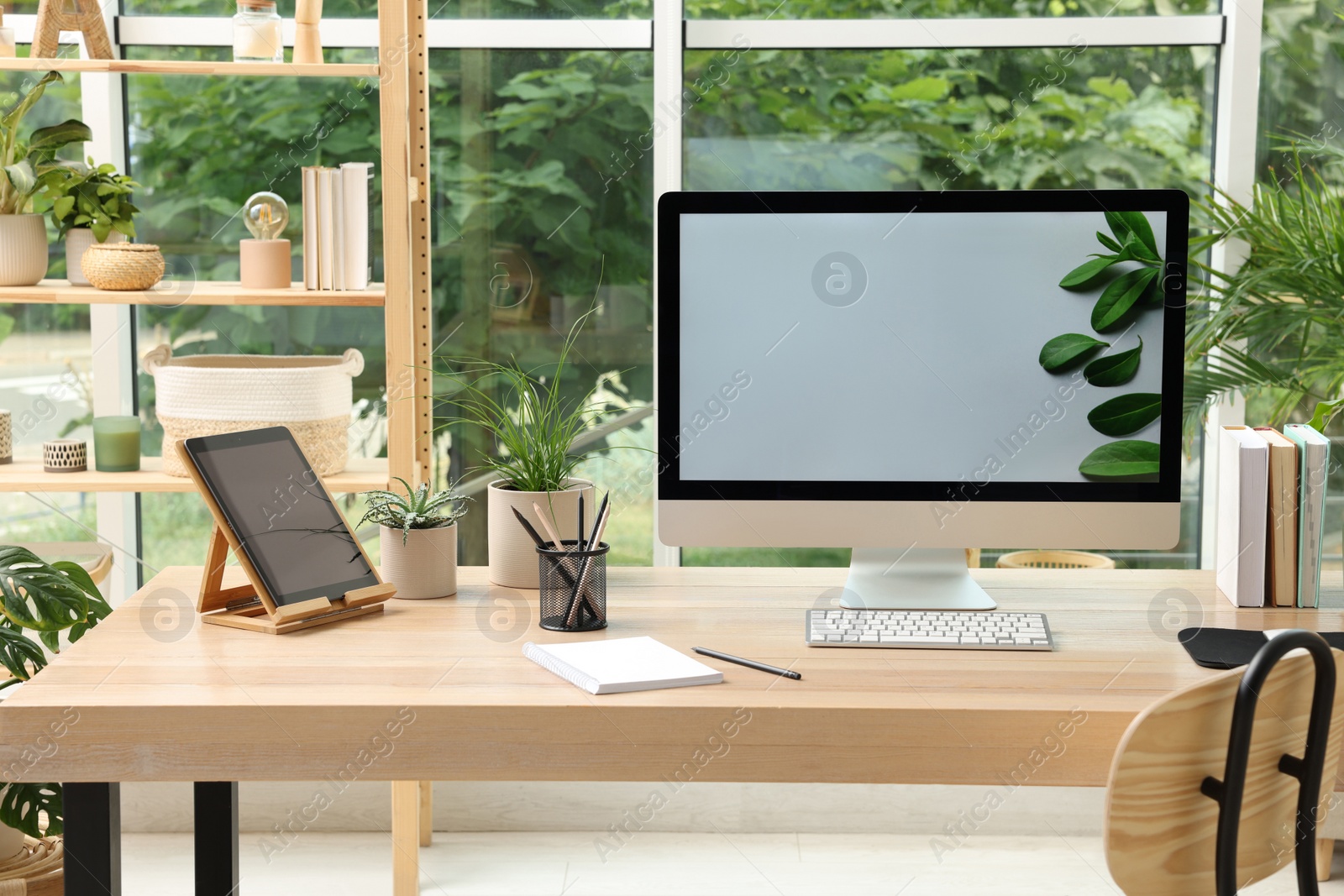 Photo of Comfortable workplace with computer in light room. Interior design