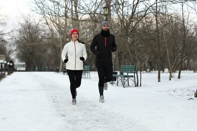 Happy people running in winter park. Outdoors sports exercises