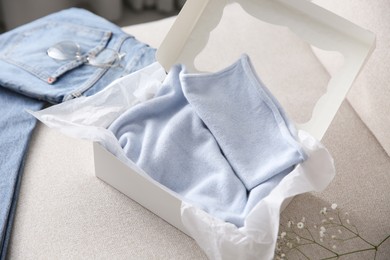 Photo of Soft cashmere sweater in box on sofa