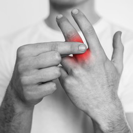 Image of Man suffering from rheumatism, closeup. Black and white effect with red accent in painful area