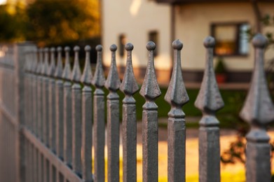 Photo of Beautiful iron fence on sunny day outdoors, closeup