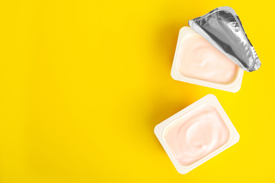 Tasty organic yogurt on yellow background, flat lay. Space for text