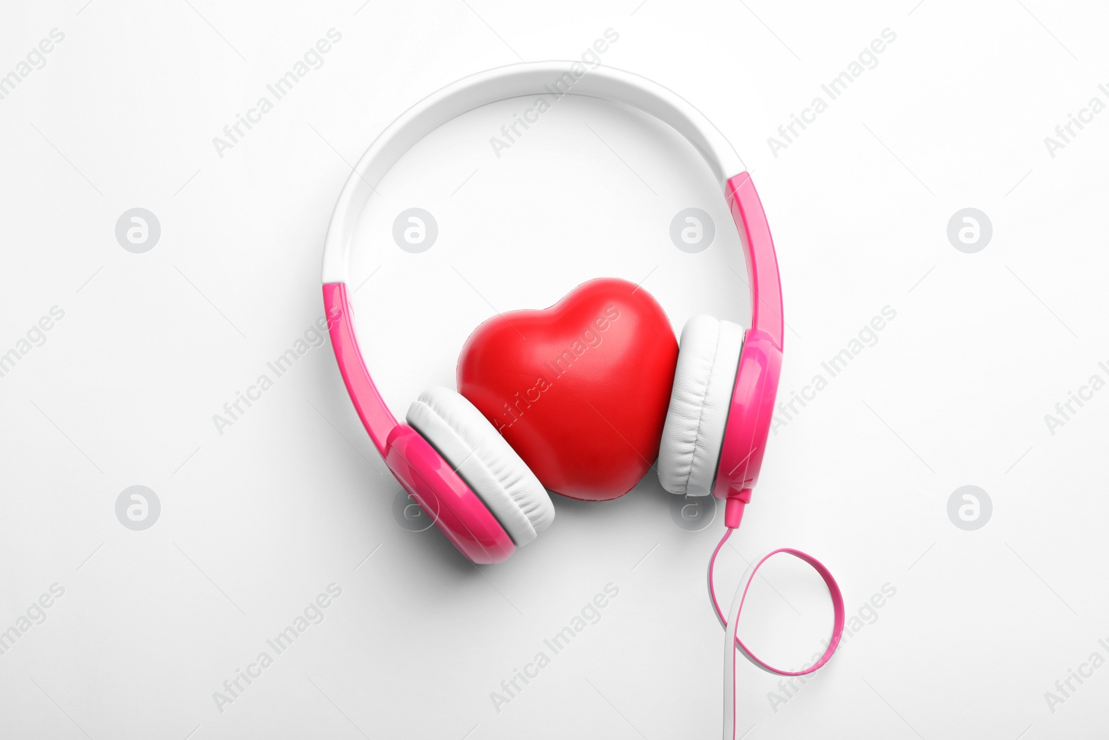 Photo of Decorative heart and modern headphones on white background, top view