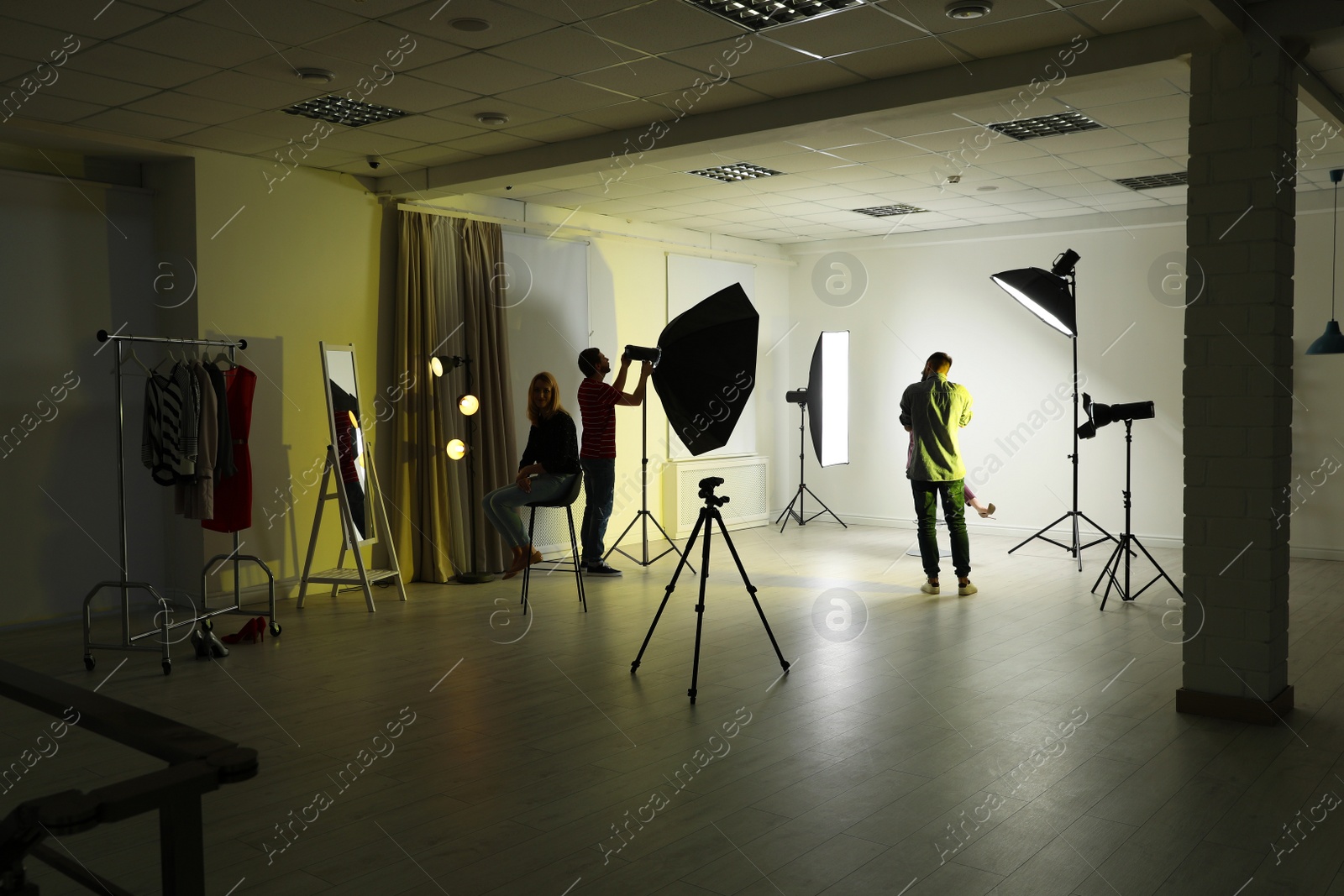 Photo of Photo studio with professional equipment and team of workers