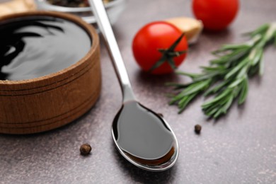 Photo of Organic balsamic vinegar and cooking ingredients on grey table, closeup