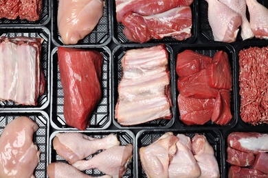 Photo of Containers with different raw meat, top view