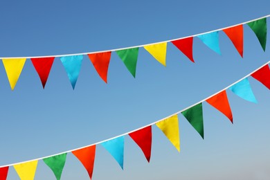 Photo of Buntings with colorful triangular flags against blue sky