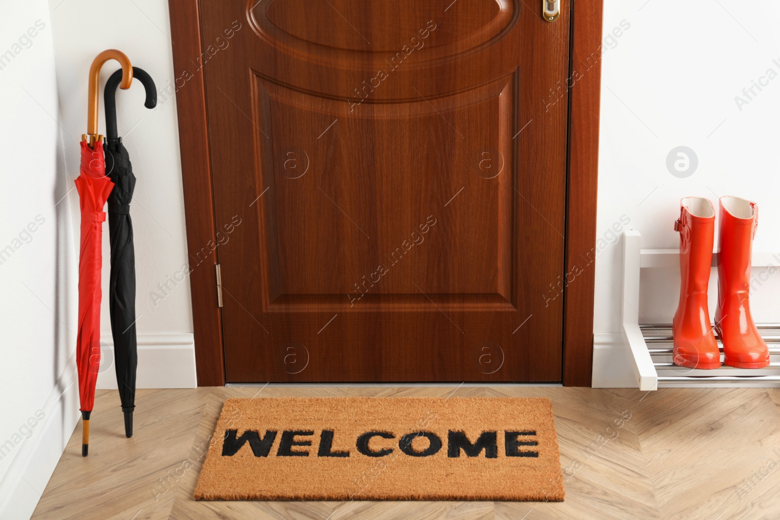 Photo of Door mat with word Welcome on wooden floor in hall