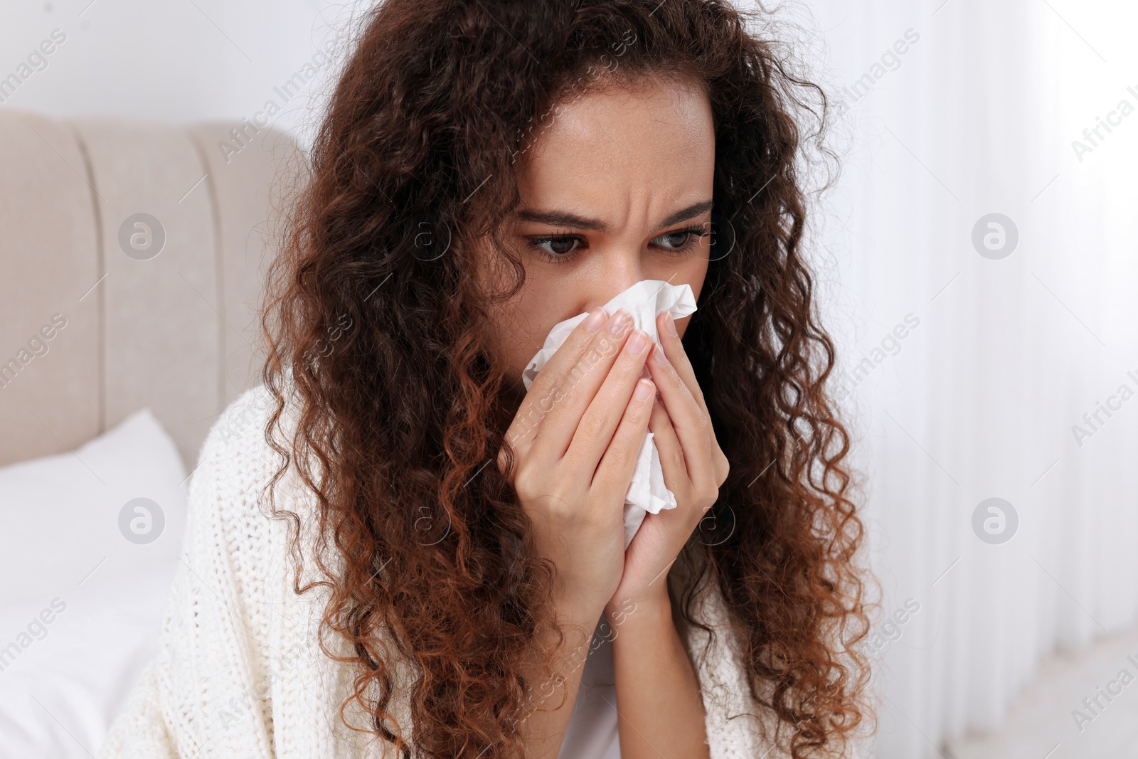 Photo of Sick African American woman with tissue in bed at home