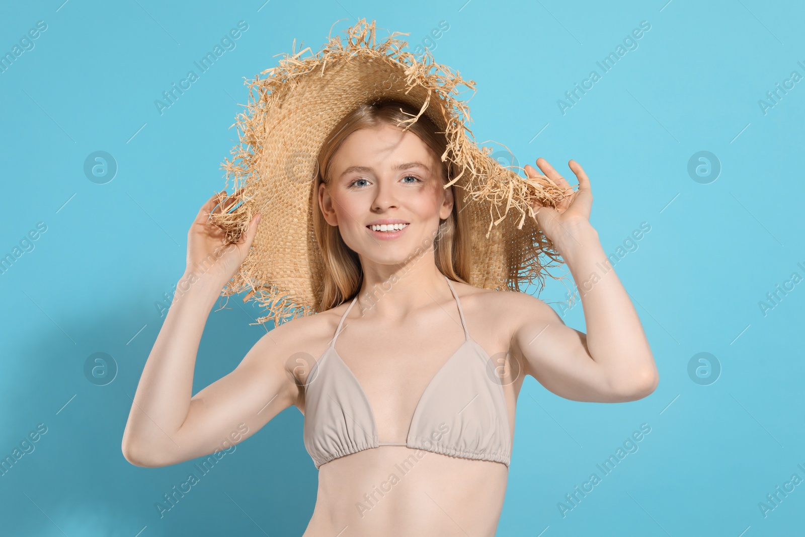 Photo of Beautiful young woman in straw hat on light blue background