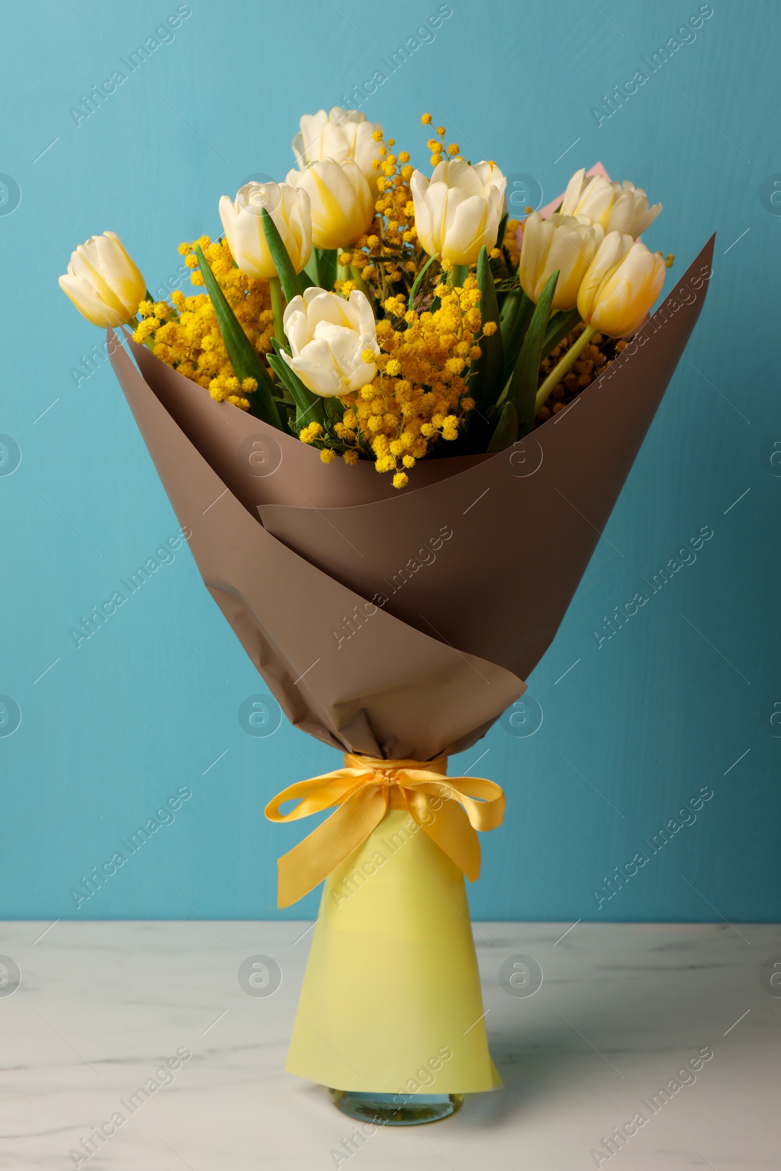 Photo of Bouquet of beautiful spring flowers on white marble table