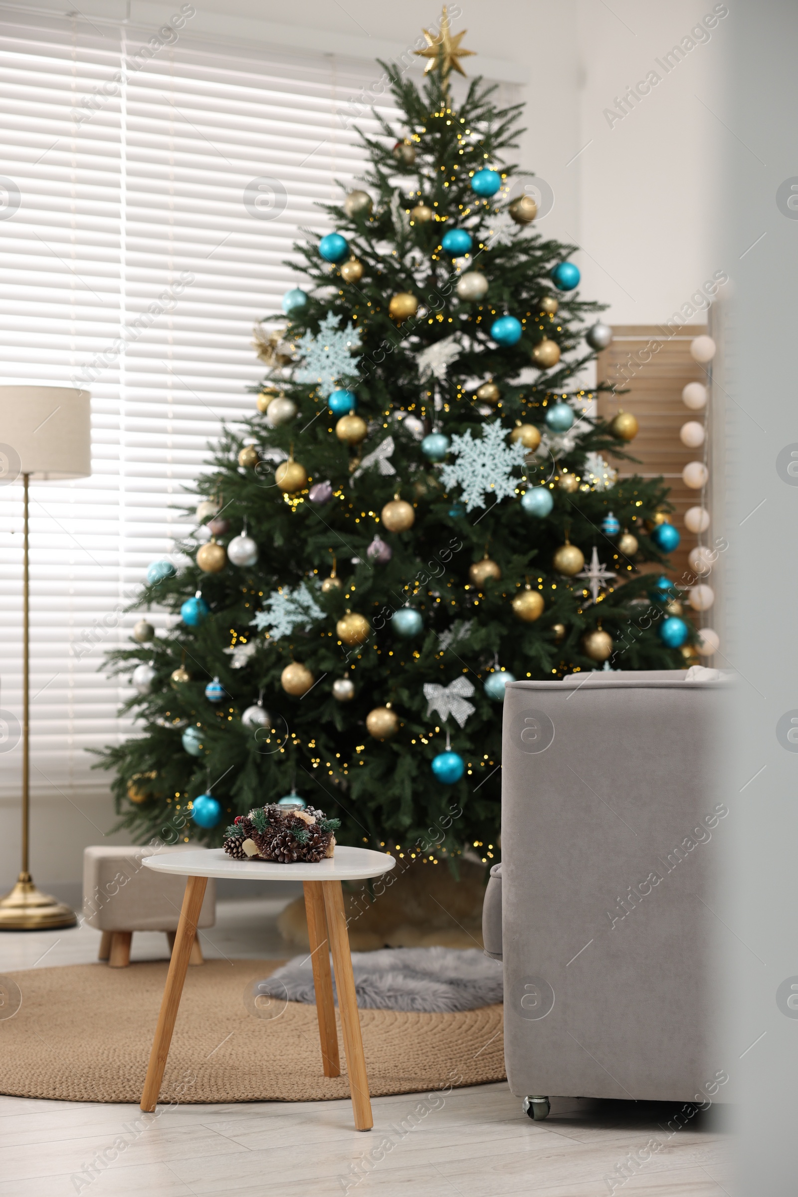 Photo of Christmas tree in room decorated for holiday. Festive interior design