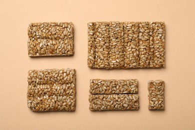 Photo of Delicious kozinaki bars on beige background, flat lay