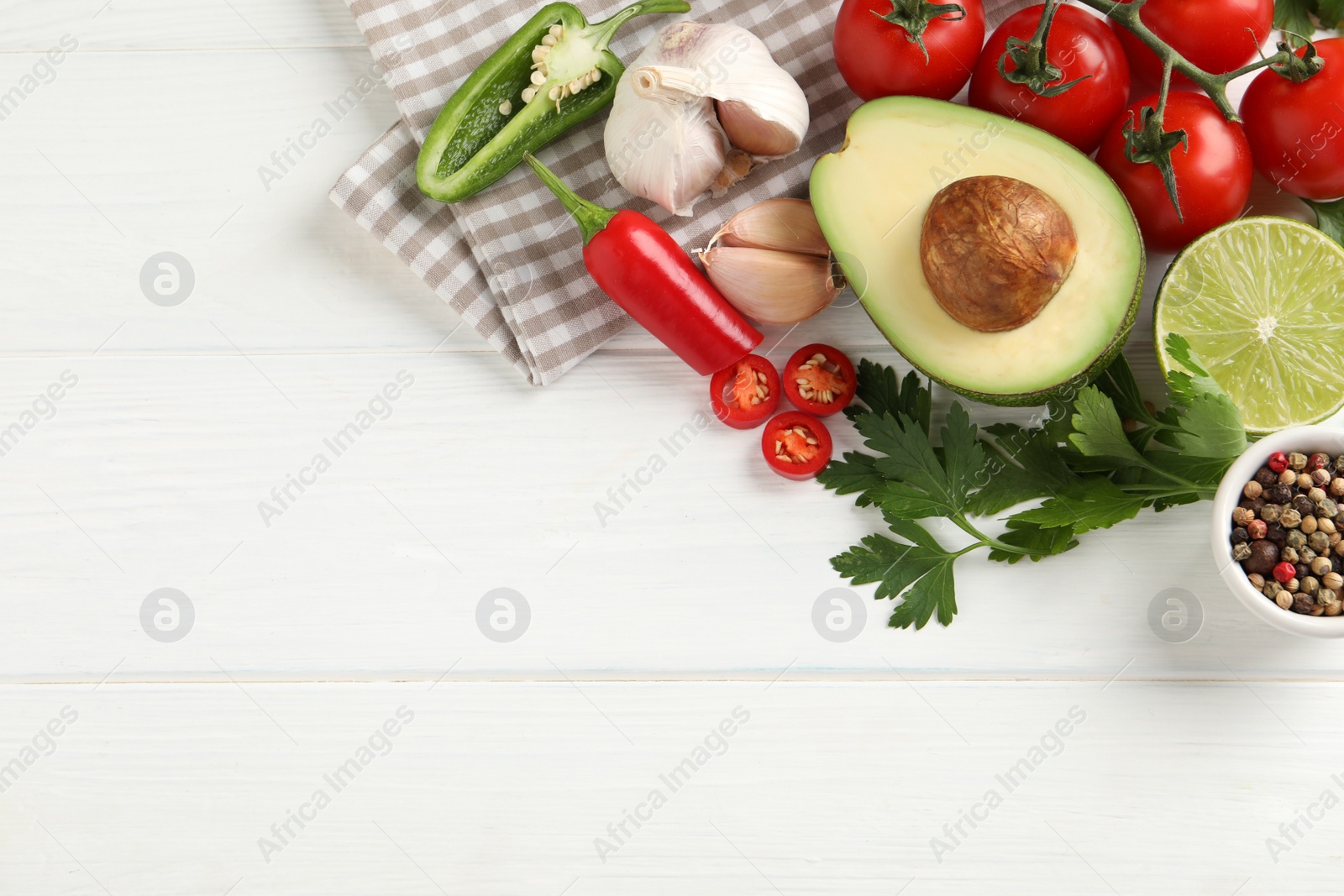 Photo of Fresh guacamole ingredients on white wooden table, flat lay. Space for text