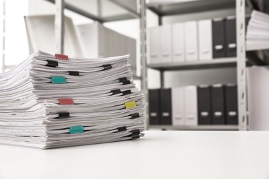 Stack of documents with paper clips on office desk. Space for text