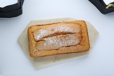 Delicious homemade yogurt cake with powdered sugar on white background, top view