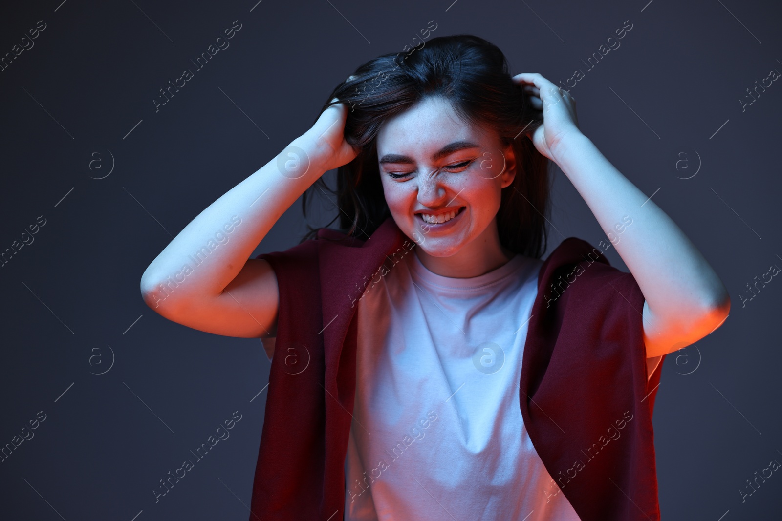 Photo of Portrait of happy woman on dark blue background in neon lights