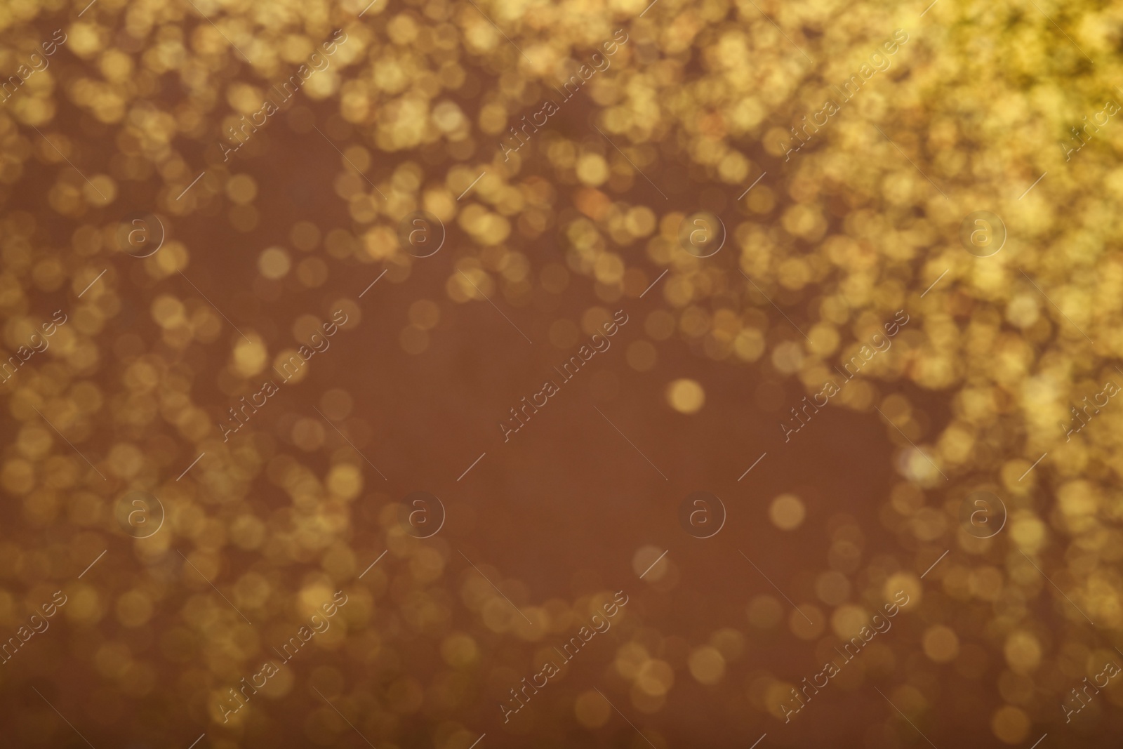 Photo of Blurred view of golden glitter on dusty rose background. Bokeh effect