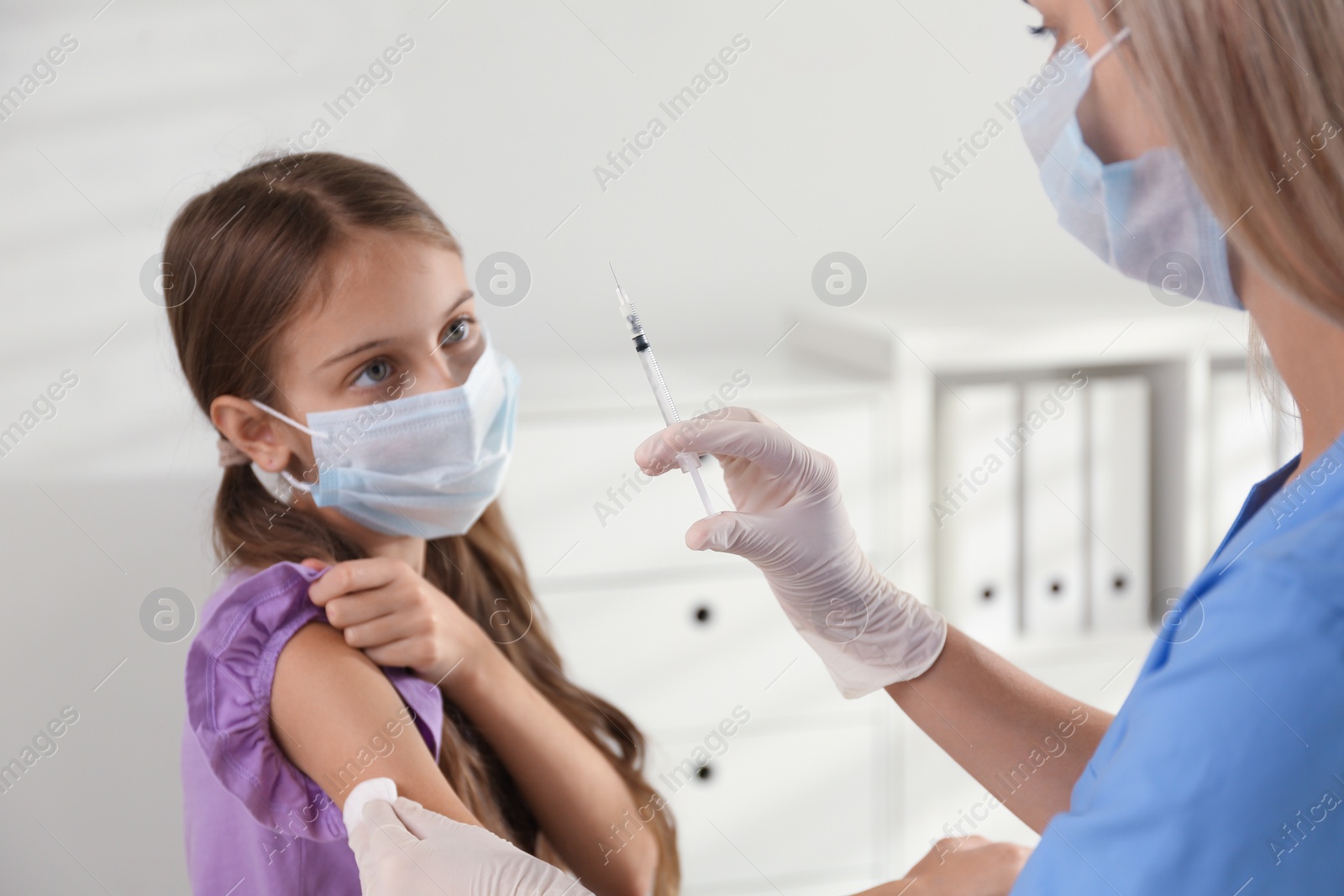 Photo of Doctor vaccinating little girl in hospital. Health care