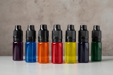 Photo of Bottles with different food coloring on white table