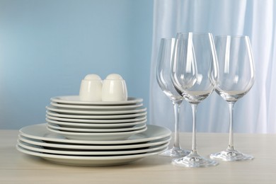 Set of clean dishware and glasses on light grey table