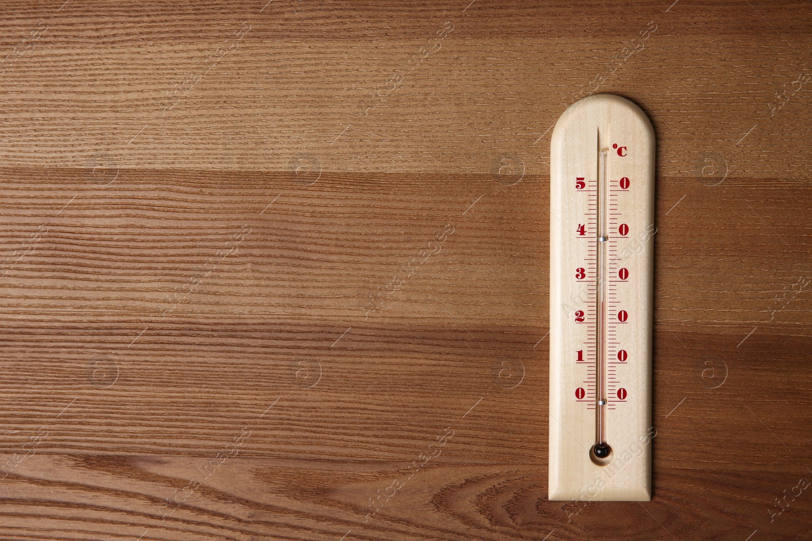 Photo of Weather thermometer on wooden table, top view. Space for text