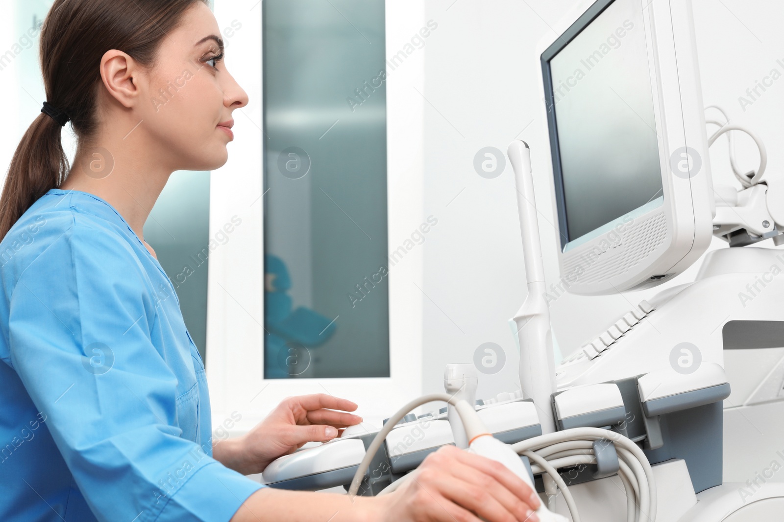 Photo of Sonographer operating modern ultrasound machine in clinic