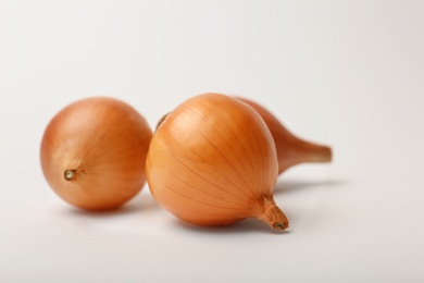 Photo of Fresh ripe onion bulbs on light background