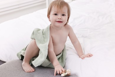 Photo of Cute little baby with towel after bathing on bed