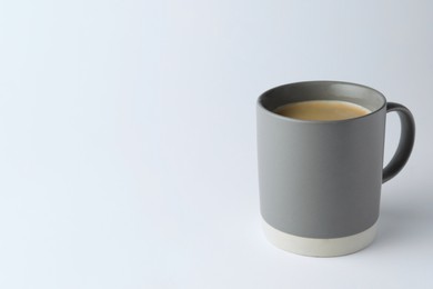 Photo of Grey mug of freshly brewed hot coffee on white background, space for text