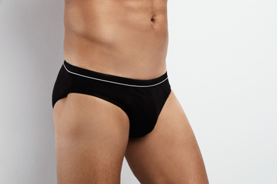 Man in black underwear on white background, closeup