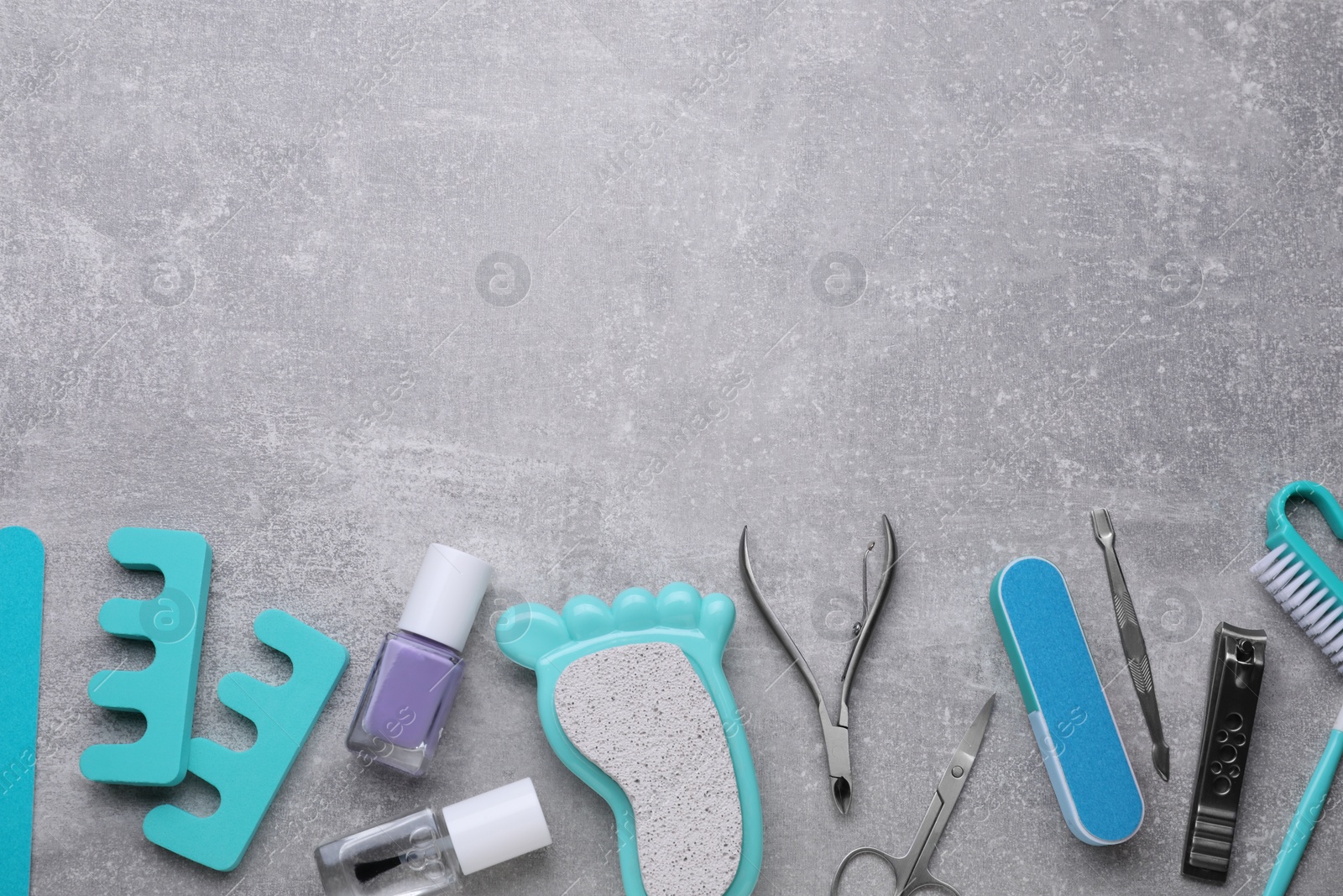 Photo of Set of pedicure tools on light gray table, flat lay. Space for text