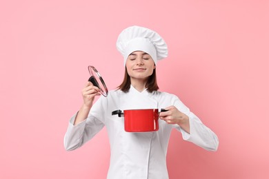 Photo of Professional chef with cooking pot on pink background