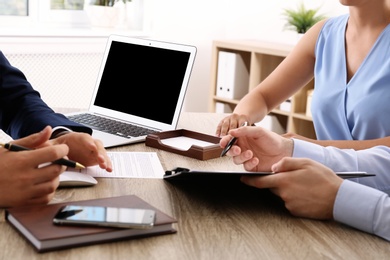 Photo of Lawyer working with clients at table in office, focus on hands