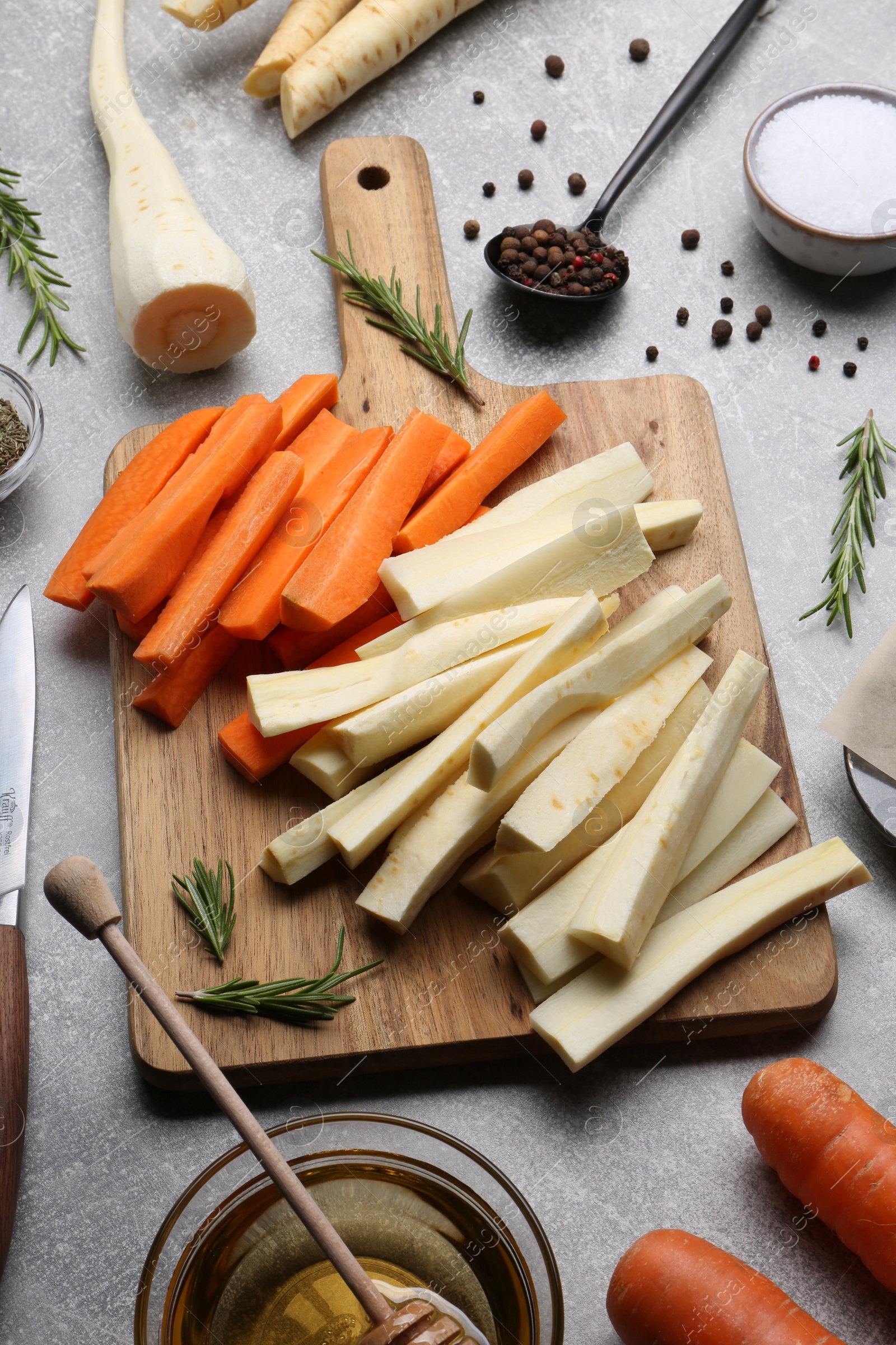 Photo of Composition with parsnips, carrots and other products on light grey table