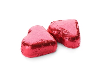 Photo of Heart shaped chocolate candies in red foil on white background