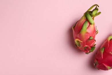 Delicious pitahaya fruits on light pink background, flat lay. Space for text