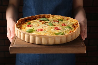 Photo of Woman with delicious homemade cheese quiche indoors, closeup