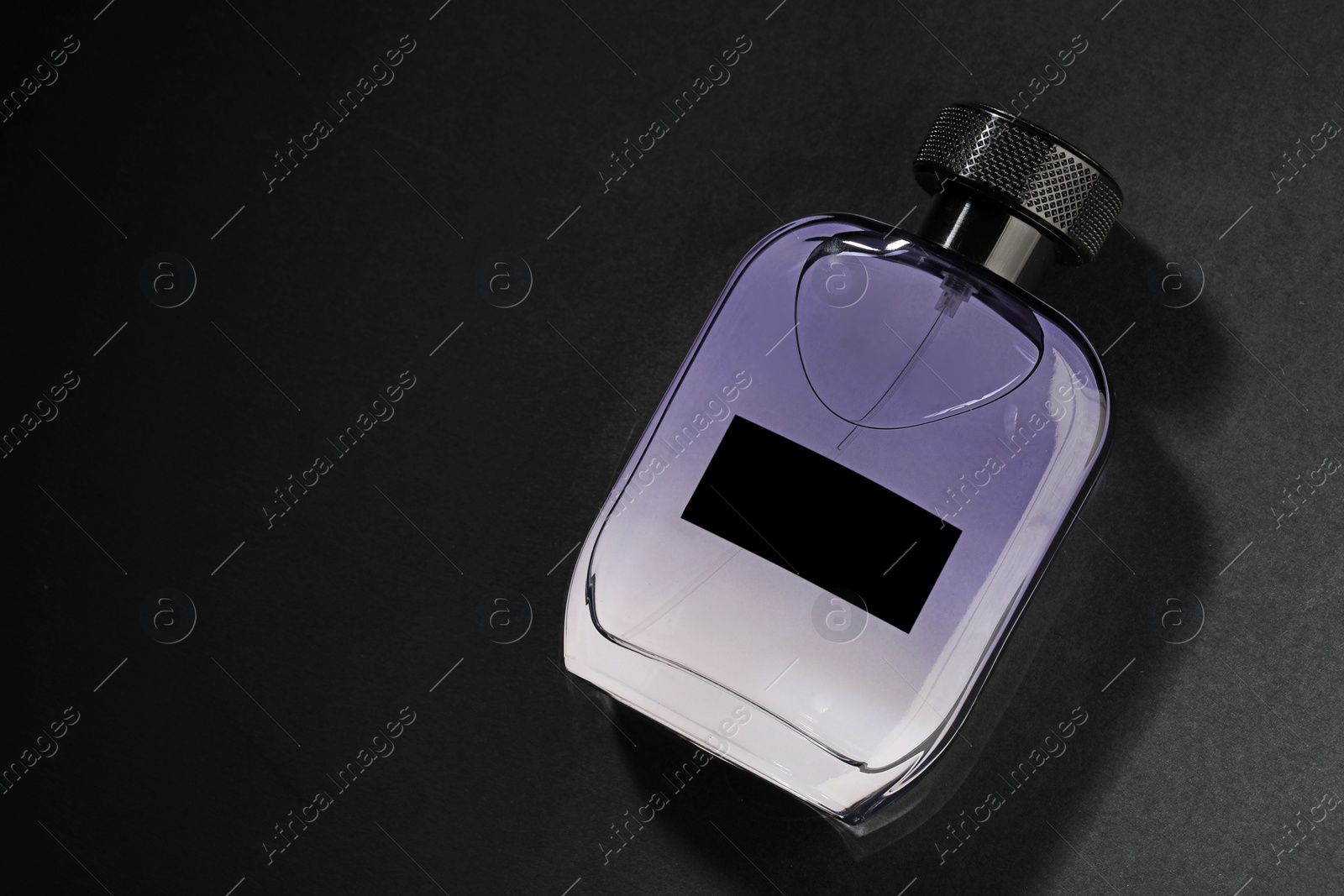 Photo of Luxury men`s perfume in bottle on black background, top view. Space for text