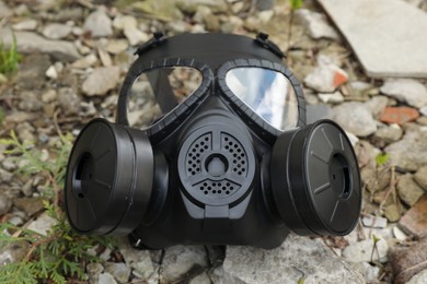 One gas mask on ground outdoors, closeup