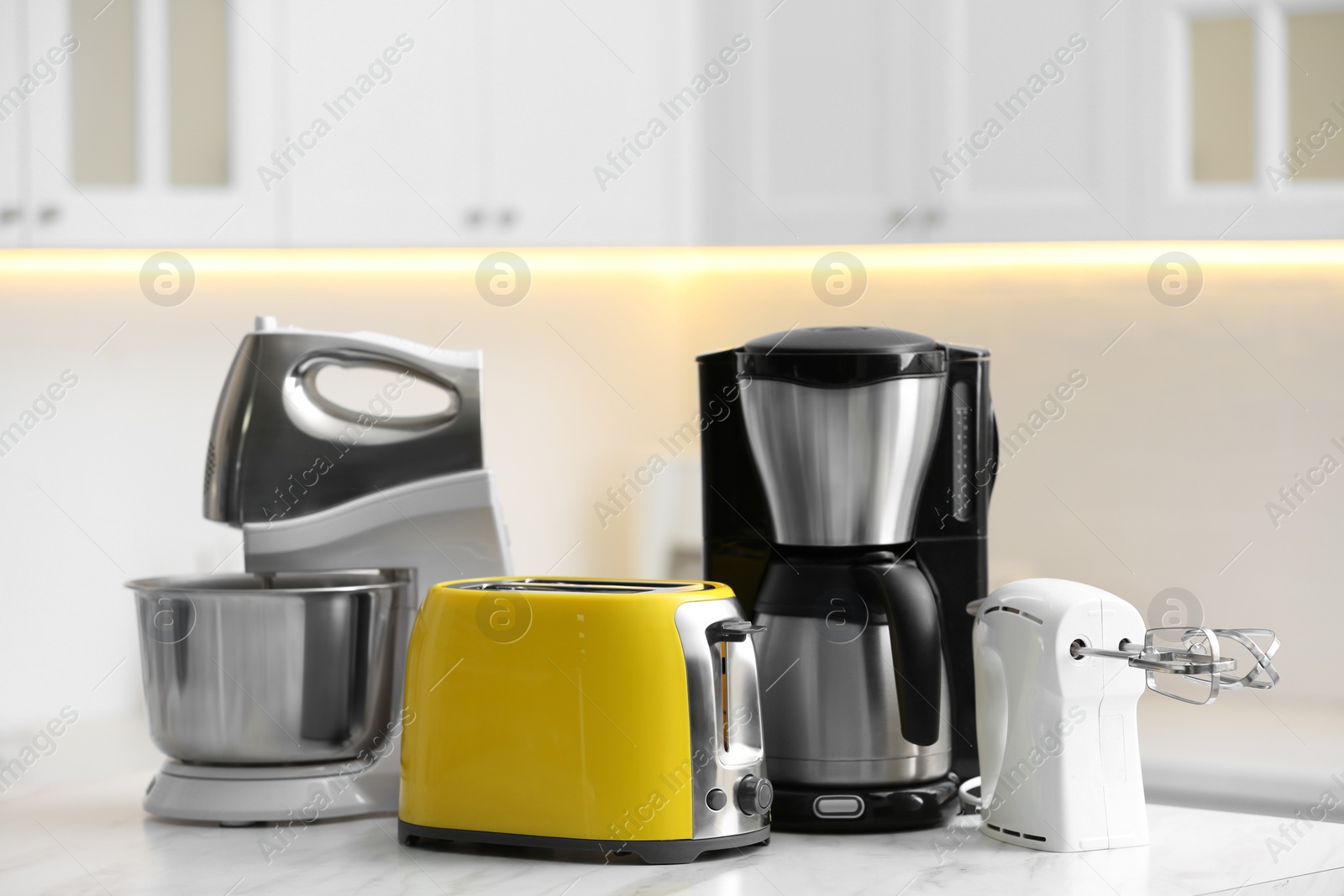 Photo of Modern toaster and other cooking appliances on table in kitchen