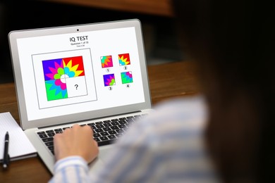 Woman using laptop for taking IQ test indoors, closeup