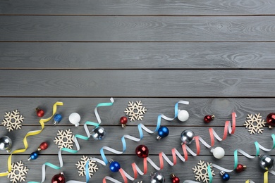 Flat lay composition with serpentine streamers on grey wooden background, space for text