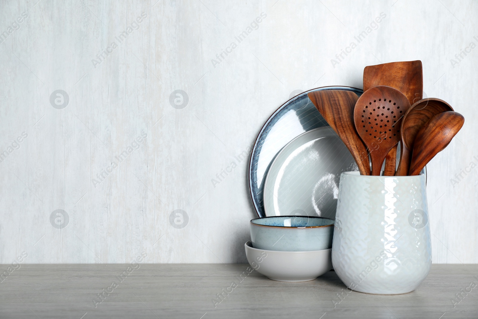 Photo of Set of kitchen utensils on light table, space for text